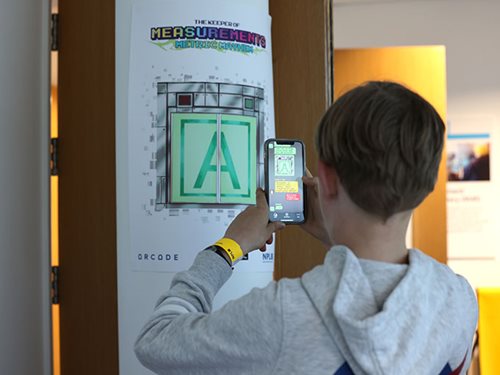 Student using phone to play keeper of measurements app