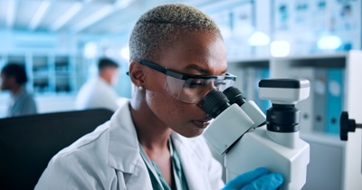 Scientist using an optical microscope illustrating the resolution limits of light-based imaging